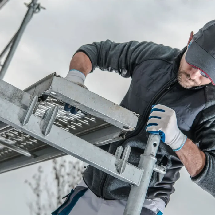 Worker assembling metal frame scaffold system for Sacramento Scaffolding